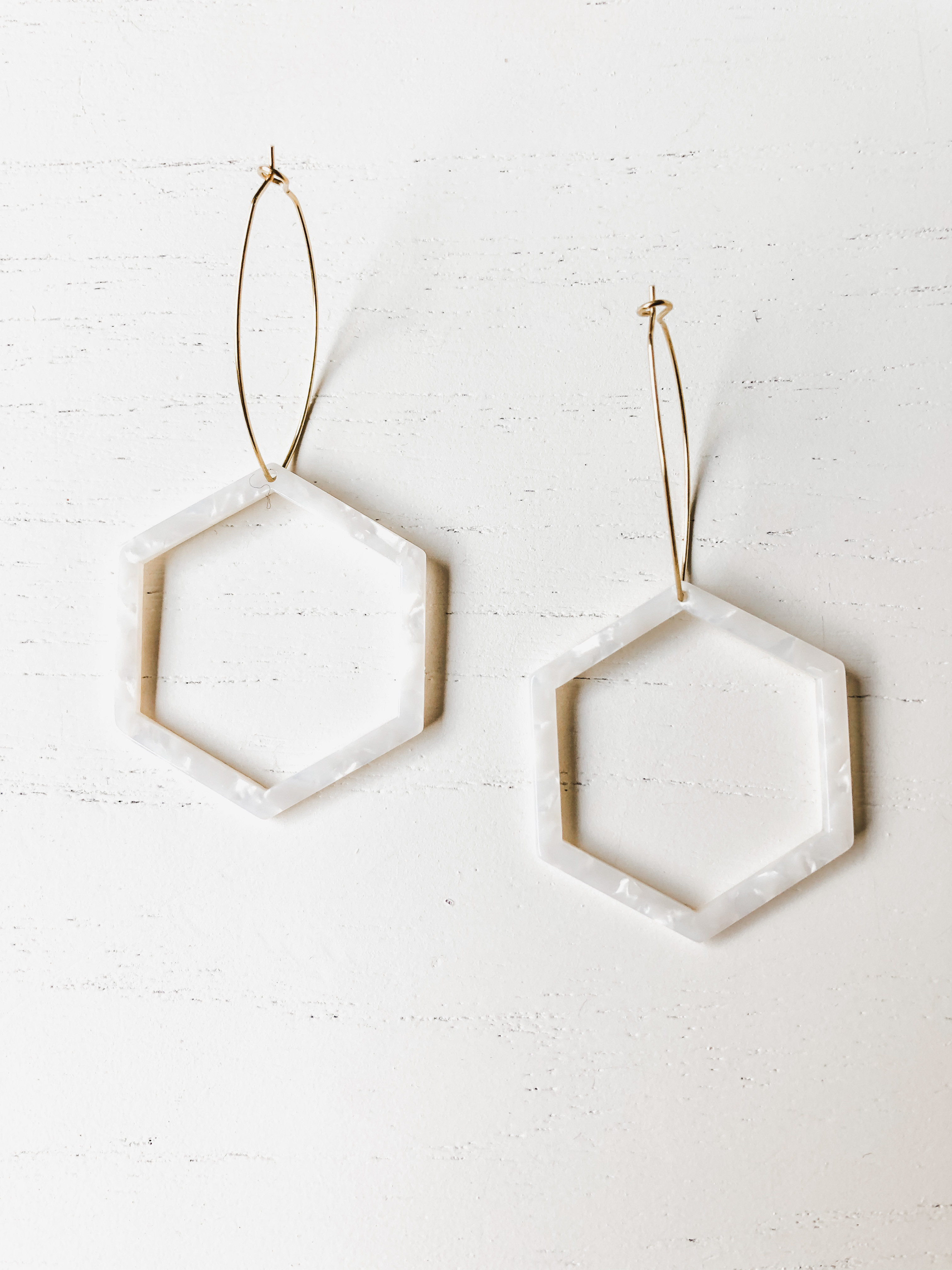 The Mae White Tortoise earrings featuring brass hoops and white tortoise shell resin detail, measuring approximately 3 inches in length.